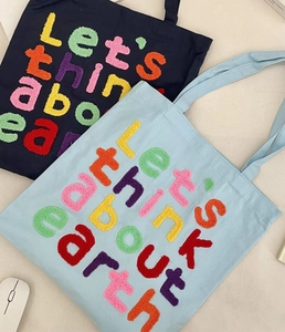 Detail showing colorful chenille letter embroidery on high-quality canvas tote bags