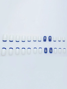 Macro view of 24pcs blue French tip press-on nails with golden star patterns