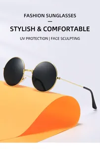Nahaufnahme der runden Retro-Sonnenbrille mit Goldmetallrahmen auf orangefarbenem Stand