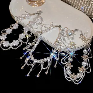 Elegant floral pearl tassel necklace with sparkling rhinestones on a ceramic platter