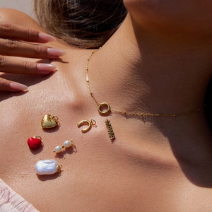 Detail of gold-plated stainless steel necklace with interchangeable pearl and MAMA heart charms