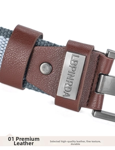 Detail of woven canvas belt showing brown leather trim and gray pin buckle fastening