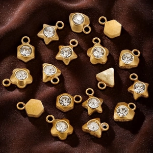 Golden stainless steel star and heart pendants with clear zircons on brown velvet