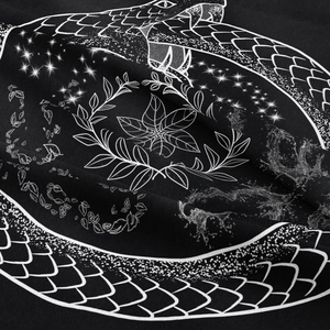 Close-up of bohemian snake and stars print on textured black fabric tapestry