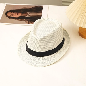 Detail of white straw fedora with black ribbon band and breathable woven texture
