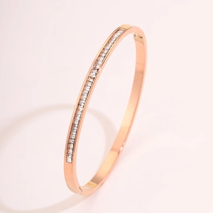 Detail of rose gold titanium steel bangle featuring a precise channel of square-cut crystals