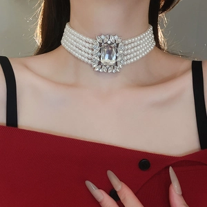 Macro view of multi-layered pearl choker necklace with square crystal pendant detail