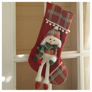 Detail of red Christmas stocking with 3D plush snowman and classic plaid patterns