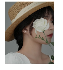 Detail of S925 sterling silver flower stud earring worn by model in an elegant setting