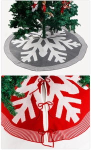 Close-up of knitted red Christmas tree skirt with white snowflake pattern and bow ties