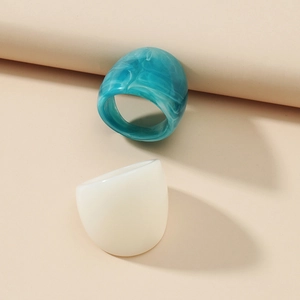 Detail of teal marble and milk white resin ring set on minimalist geometric background