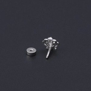 Detail view of crown shaped ear stud with screw back post and flat metal disc backing