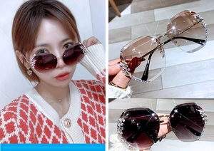 Close-up of oversized rimless sunglasses featuring geometric gradient lenses and sparkling rhinestones