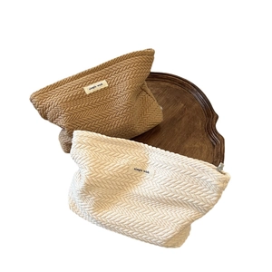 Woven fabric cosmetic bags in brown and cream with textured V-pattern and 'simple wish' tag