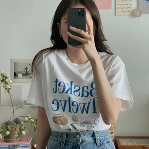 Mirror selfie showing a vintage white cotton T-shirt with blue art and bread graphic