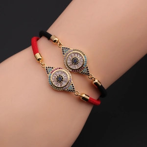 Detail of red and black braided evil eye bracelets with gold plating and zircons