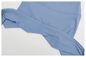 Dettaglio macro dei leggings da yoga blu che mostra cuciture piatte su tessuto elastico