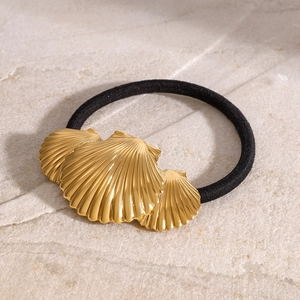 Minimalist stainless steel hair tie featuring a golden shell charm on a black elastic band