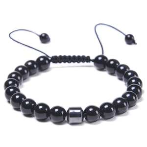 Detail of adjustable woven cord on black beaded bracelet with metallic cylinder accent