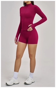 Détail de la veste de yoga magenta ajustée avec col montant et passants pour les pouces