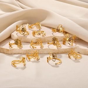 Set of 12 adjustable stainless steel floral rings with zircon accents on stone surface
