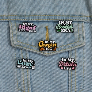 Detail of five colorful inspirational enamel pins on denim jacket featuring trendy quotes