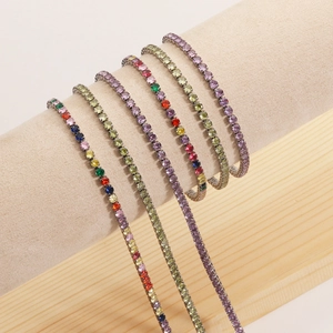 Detail of five tennis bracelets with multicolor zircons on a beige velvet jewelry display