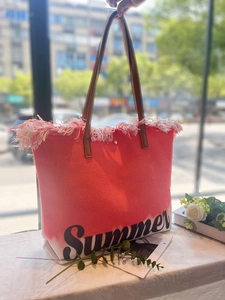 Makro-Detail der rot schattierten Strandtasche mit Fransen und Summer-Schriftzug