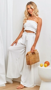 Détail d'un ensemble bohème blanc avec haut bandeau et pantalon large en lin