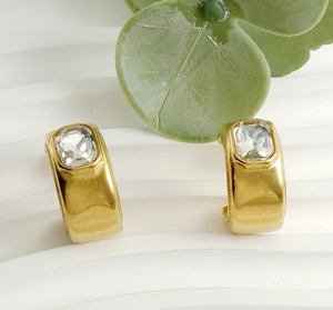 Détail macro de boucles d'oreilles en C plaquées or 18 carats avec cristaux de zircone