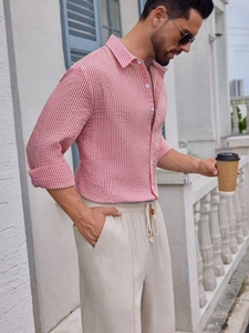 Close-up of red and white striped seersucker shirt fabric texture on a male model