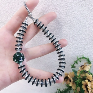 Handmade phone strap with black beads and a large green rhinestone-encrusted charm