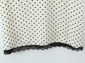 Detalle de tela blanca de lunares con exquisito ribete de encaje negro y textura ligera