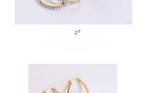 Macro detail of oversized gold-plated egg-shaped earrings with sparkling cubic zirconia pavé