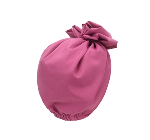 Detail of dark pink turban hat featuring elegant pleated knot and soft fabric texture
