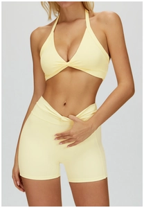 Detail of light yellow yoga set with halter bra and v-shaped cross waist shorts