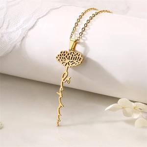 Detail of gold floral pendant with Be Positive engraving and hollow lotus design