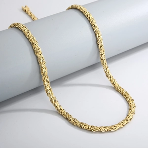 Détail macro d'un collier chaîne corde dorée montrant la texture et l'artisanat industriel
