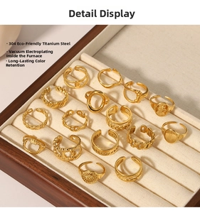 Detail view of gold-plated stainless steel ring set displayed in a beige velvet jewelry box