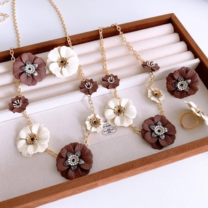 Detailed macro view of vintage floral jewelry set with brown and cream flower petals