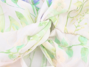 Detail of floral embroidery and elegant front knot design on a green maxi dress fabric