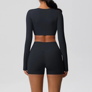 Back view of a black two-piece yoga set featuring a long sleeve crop top and biker shorts