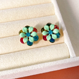 Detail of vintage flower stud earrings with green enamel and colorful crystals in a gift box