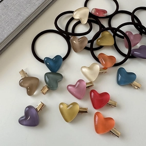 Close-up of translucent jelly heart hair clips and elastic bands in pastel colors