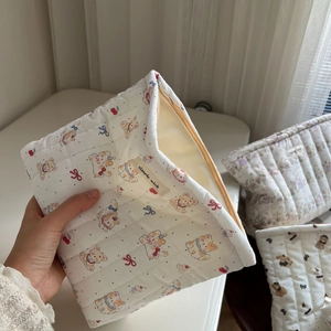 Detailed close-up of quilted cotton cosmetic bag featuring cartoon bear and cherry prints