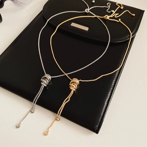Detail of gold and silver zircon circle pendant necklaces on black leather background