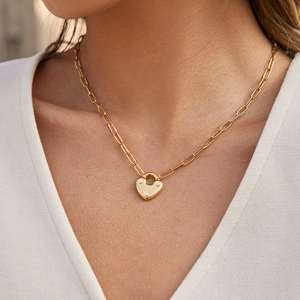 Collier élégant à médaillon cœur doré avec chaîne trombone sur un mannequin