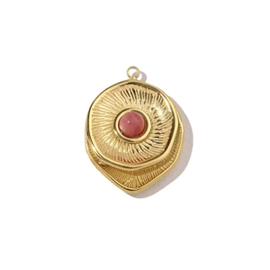 Detail of 14k gold-plated round pendant with red agate stone and radial texture