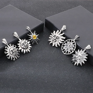 Detailed view of vintage sun totem pendants in silver finish with aged metal texture