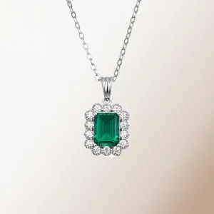 Macro view of emerald-cut green gemstone necklace with halo diamond setting